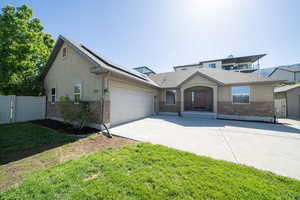 View of front of home with a garage and a front lawn