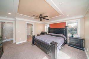 Carpeted bedroom with multiple windows and ceiling fan