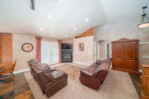 Living room with tile floors, french doors, and lofted ceiling