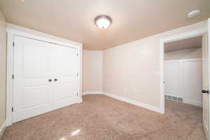 Unfurnished bedroom featuring a closet and carpet floors