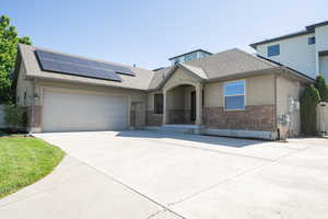 View of front of property featuring a garage and solar panels