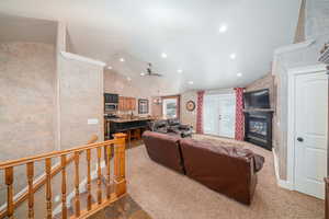 Living room featuring carpet, french doors, and lofted ceiling