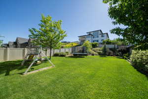 View of yard featuring a playground and a trampoline