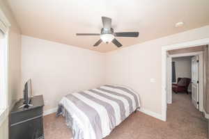 Carpeted bedroom featuring ceiling fan