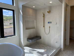 Bathroom featuring plus walk in shower and plenty of natural light