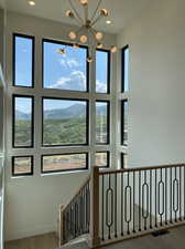 Stairway featuring a wealth of natural light, a mountain view, a notable chandelier, and hardwood / wood-style floors