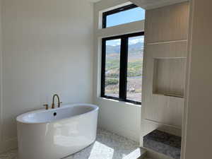 Bathroom featuring parquet floors, plenty of natural light, and a tub