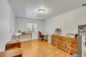 Office area featuring a textured ceiling and light wood-type flooring