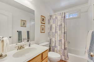 Full bathroom with shower / bath combination with curtain, vanity, and toilet