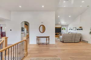 Living room featuring light hardwood / wood-style floors and lofted ceiling