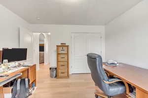 Home office featuring light hardwood / wood-style floors and a textured ceiling