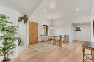 Entrance foyer with an inviting chandelier and light wood-type flooring