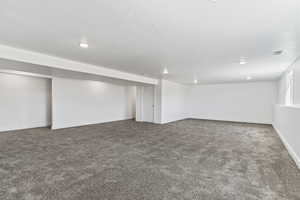 Basement with a textured ceiling and carpet floors