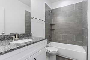 Full bathroom with tiled shower / bath, oversized vanity, hardwood / wood-style flooring, and toilet