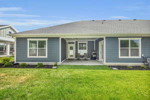 Rear view of property with a patio area and a yard