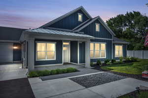 View of front of home with a garage and a yard