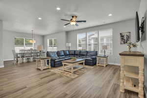 Living room with ceiling fan and light hardwood / wood-style flooring