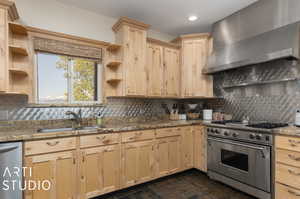 Kitchen with appliances with stainless steel finishes, sink, backsplash, and wall chimney exhaust hood