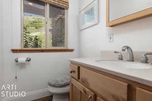 Bathroom with toilet, tile floors, and large vanity