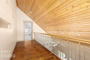 Corridor featuring a wealth of natural light, wooden ceiling, rail lighting, and lofted ceiling