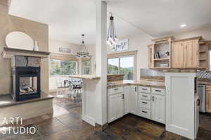 Kitchen featuring a fireplace, plenty of natural light, and kitchen peninsula