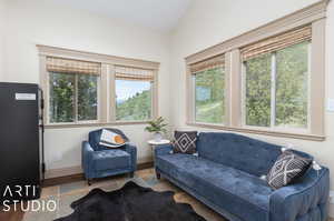 Tiled living room featuring a healthy amount of sunlight and vaulted ceiling