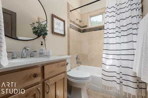 Full bathroom featuring shower / tub combo with curtain, vanity, and toilet