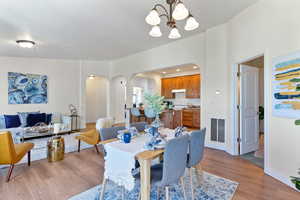 Dining space with a notable chandelier and light wood-type flooring