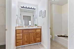 Bathroom with tile floors, a textured ceiling, toilet, and vanity