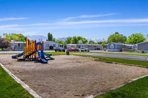 View of jungle gym featuring a mountain view and a yard