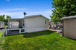 Rear view of property with a yard