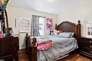 Bedroom with dark hardwood / wood-style flooring