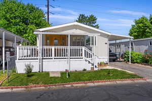 Manufactured / mobile home with a front yard and a porch