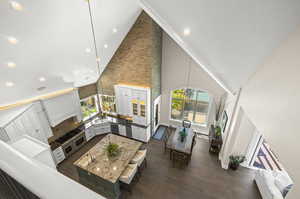 Living room with high vaulted ceiling, sink, and dark hardwood / wood-style flooring