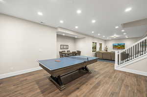 Recreation room with dark hardwood / wood-style floors