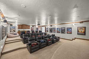 Carpeted home theater featuring a textured ceiling