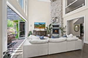 Living room featuring a high ceiling, a fireplace, and dark wood-type flooring