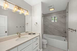 Full bathroom featuring tile floors, shower / bath combination with curtain, oversized vanity, and toilet