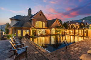 Pool at dusk featuring a patio area