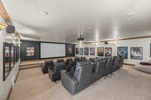 Carpeted home theater featuring a textured ceiling