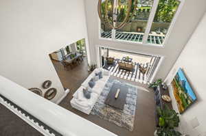 Interior space with a towering ceiling, a healthy amount of sunlight, and an inviting chandelier