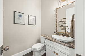 Bathroom with vanity with extensive cabinet space and toilet