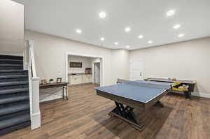 Recreation room with dark hardwood / wood-style flooring