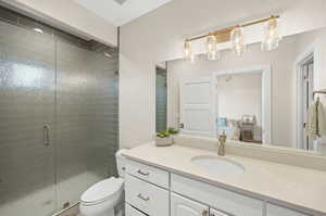 Bathroom featuring oversized vanity, toilet, and walk in shower