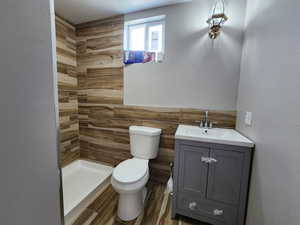 Bathroom with tile walls, toilet, walk in shower