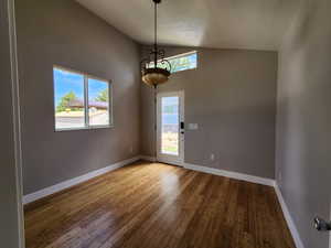 Empty room featuring high vaulted ceiling