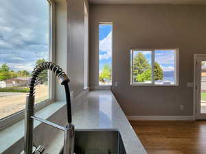 Interior space with light stone counters and wood-type flooring