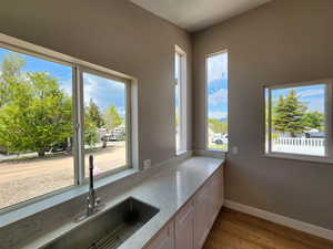 Kitchen featuring white cabinetry, a wealth of natural light, light stone countertops