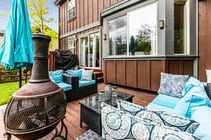 Wooden deck featuring an outdoor hangout area with firepit.