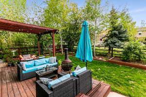 Wooden deck featuring a pergola, an outdoor hangout area, and a lawn, room for all the lawn furnitrue.